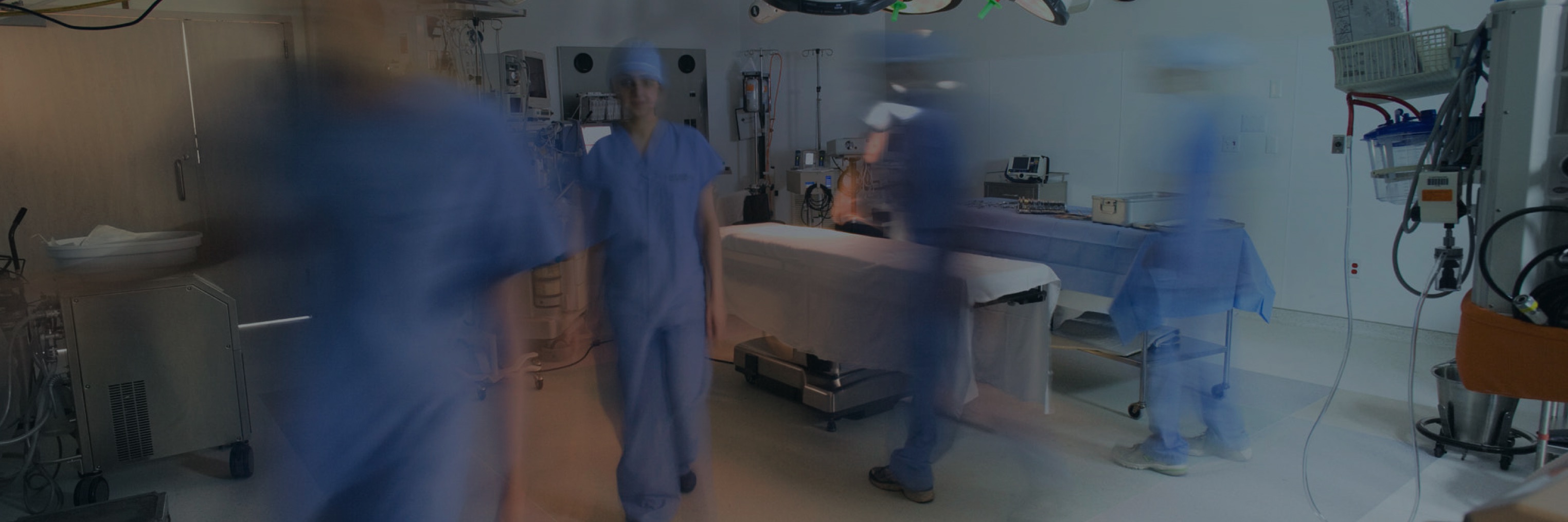 Doctors moving around in an operating room